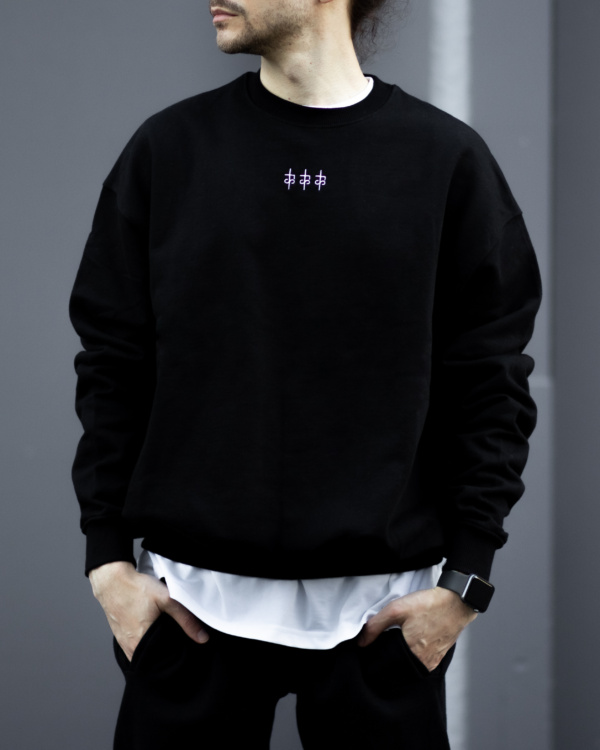 Male model wearing a black sweatshirt in 100% cotton with The Foreign Sun logo